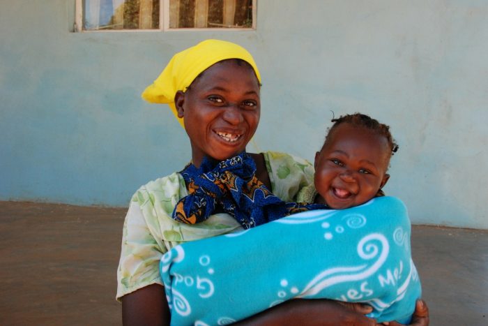 La felicidad en el rostro de esta madre y su hija no tienen precio luego de obtener una cobija con tus donaciones. 